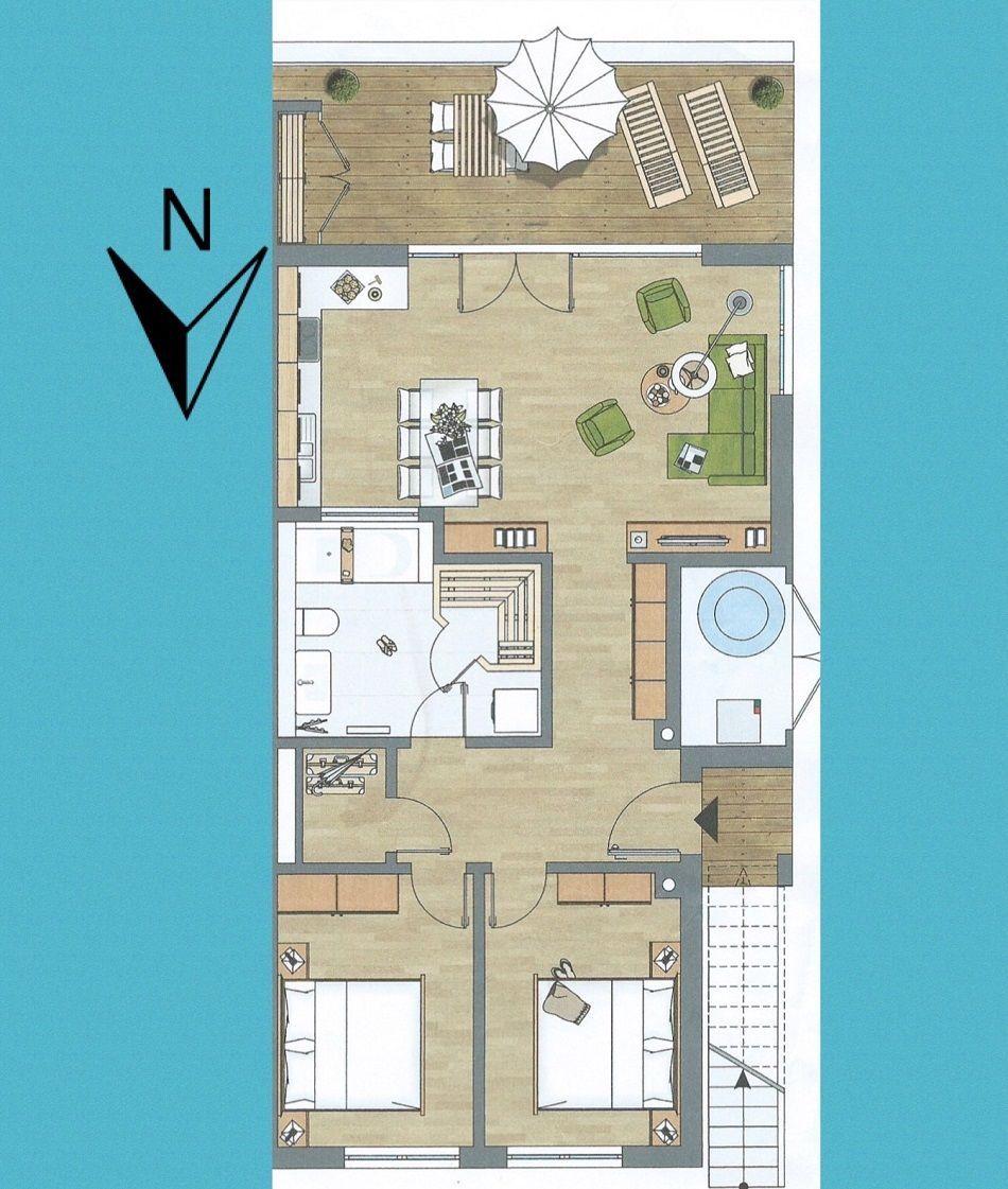 Strand mit Liegestühlen, Parkplatz und grünen Feldern entlang der Küste.