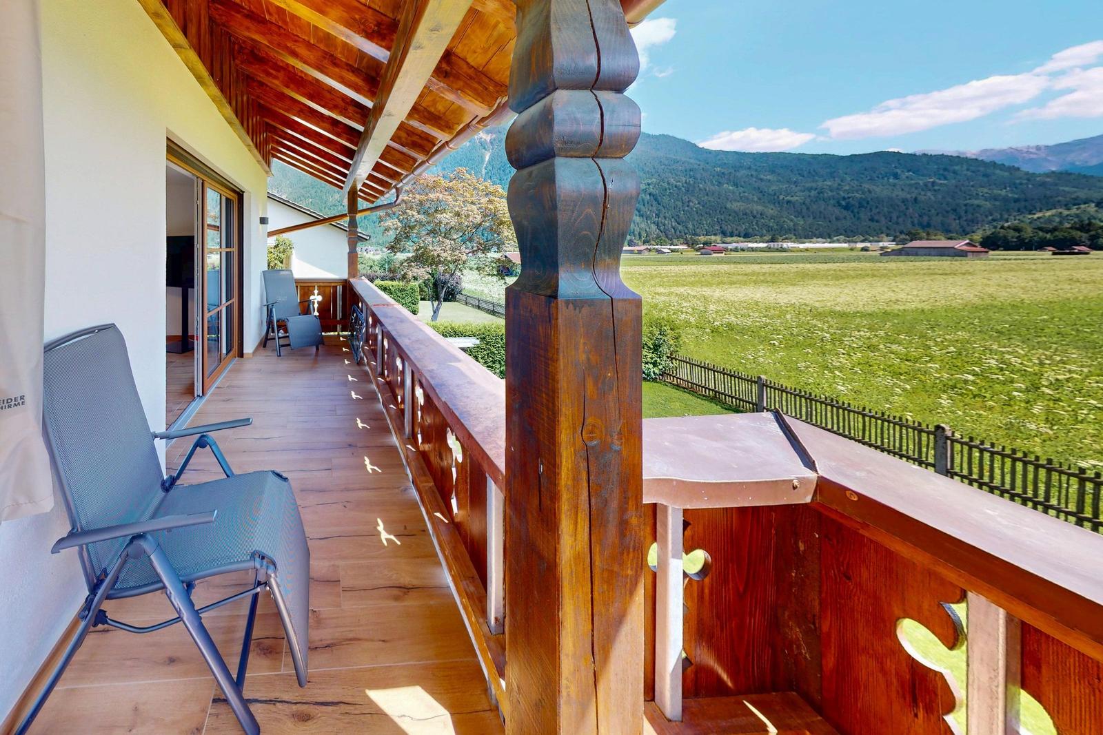 Badezimmer mit Toilette, Waschbecken und Fenster. Wandverkleidung aus Stein und Holz.