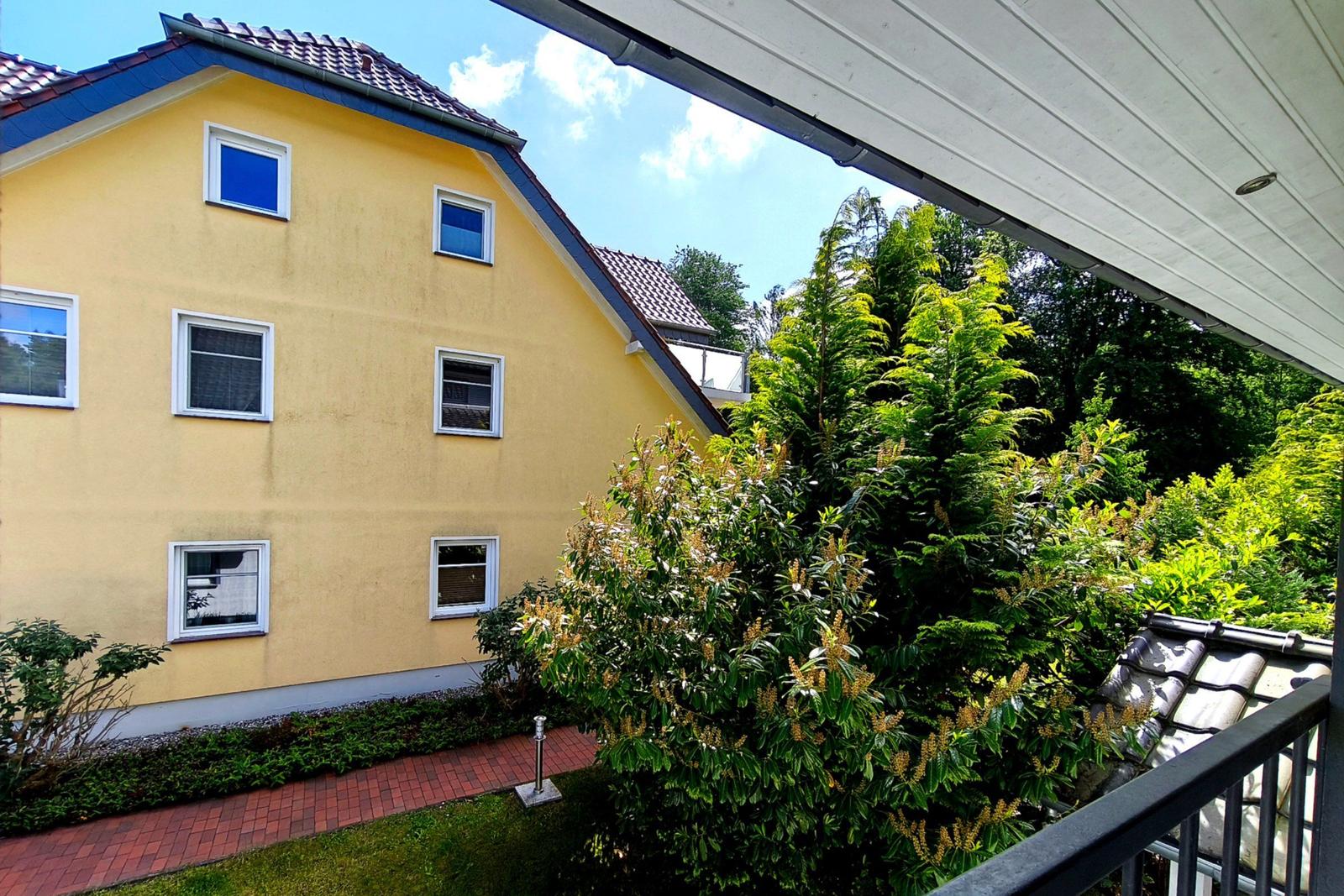 Große Rasenfläche mit Gemeinschaftsgrill inmitten der grünen Außenanlage