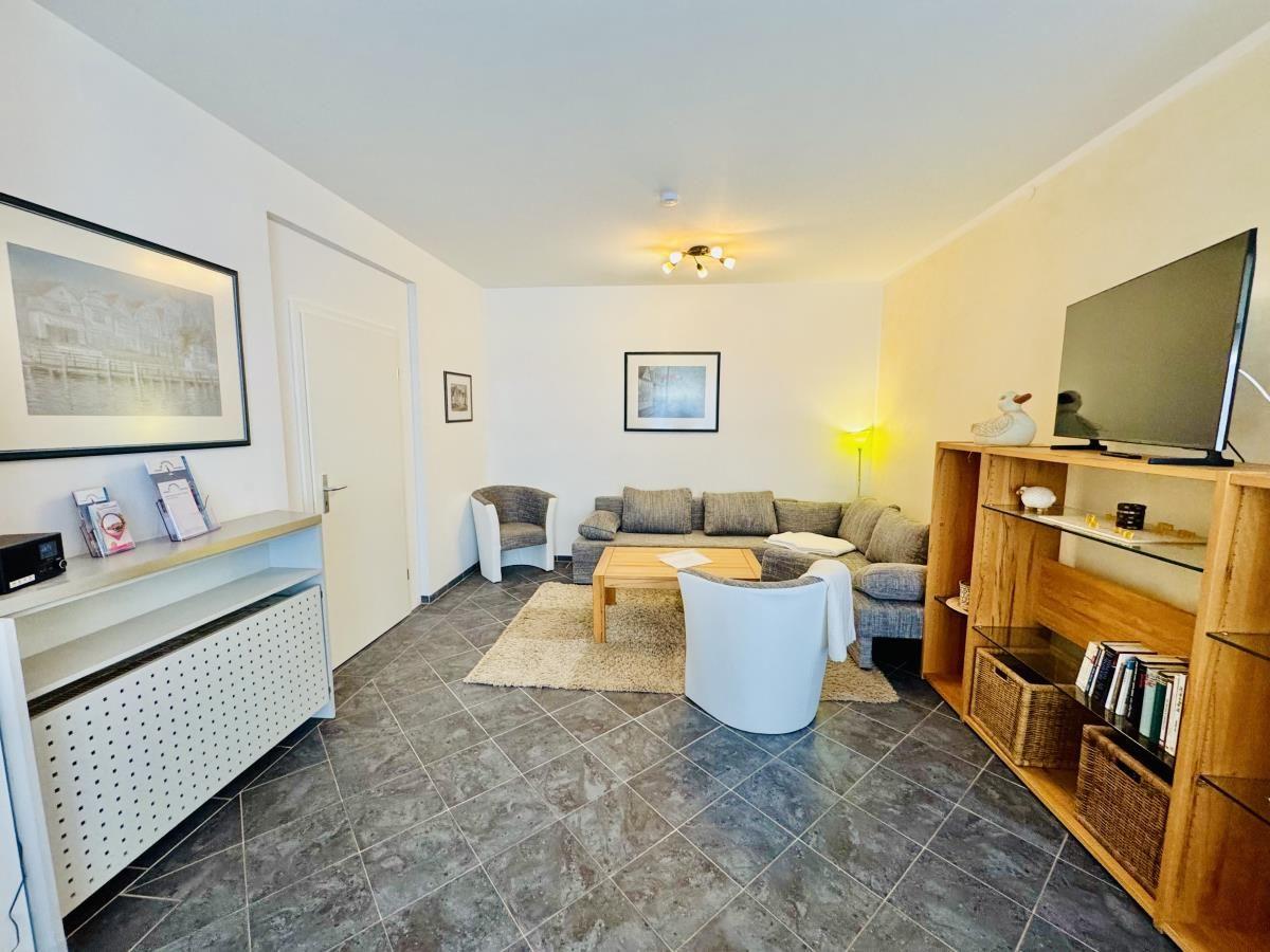 Küche mit Arbeitsplatte und Wohnzimmer mit Sofa und Sessel.