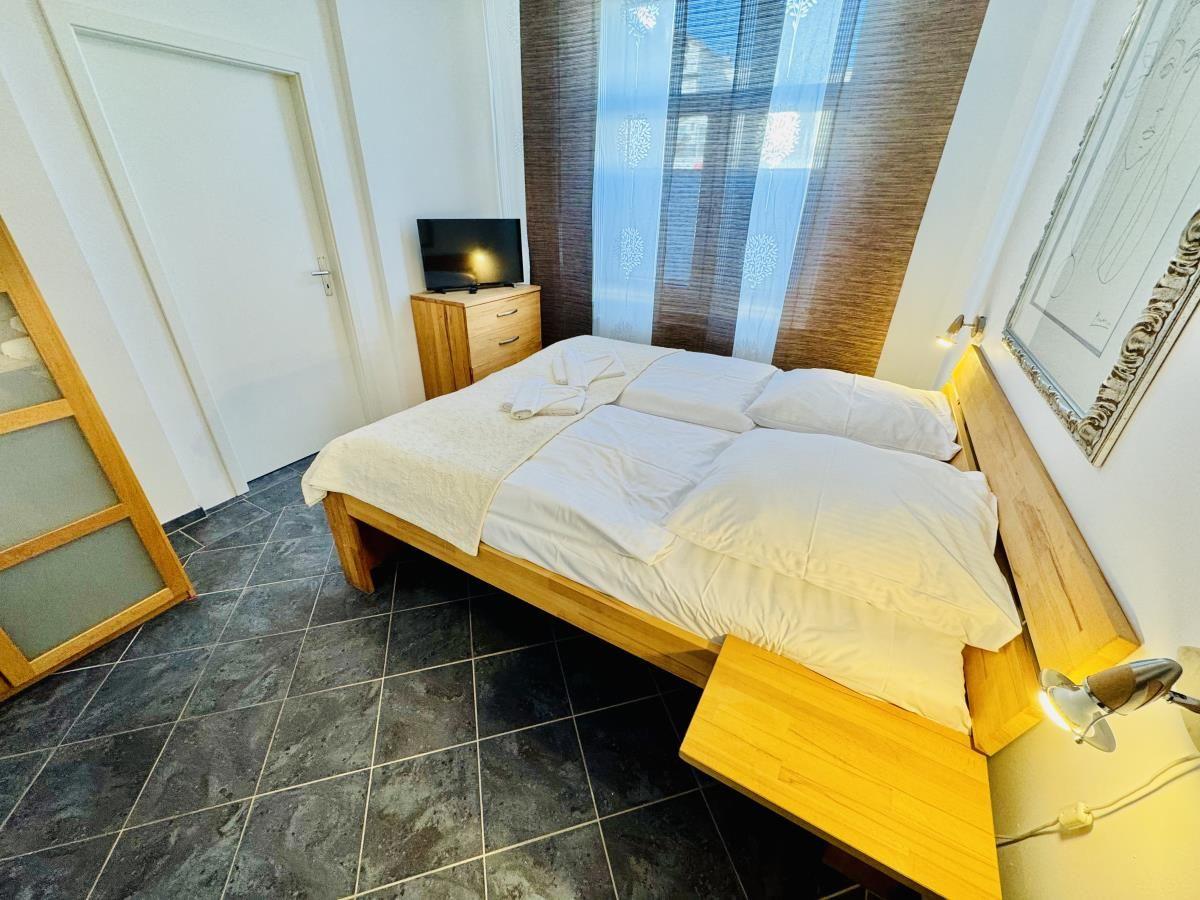 Schlafzimmer mit Doppelbett, Spiegel, Kleiderschrank und TV.