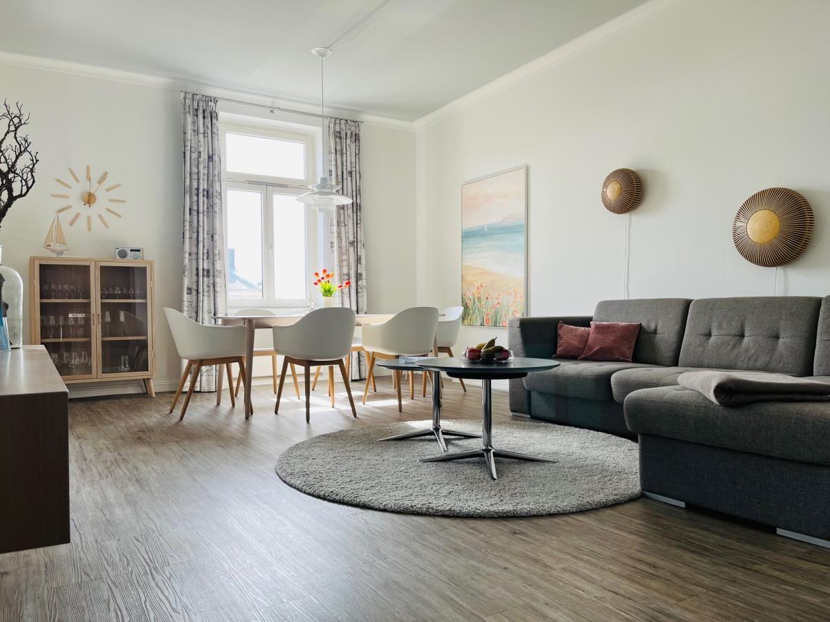 Moderne Küche mit weißen Schränken, Edelstahlgeräten und Holzdielen.