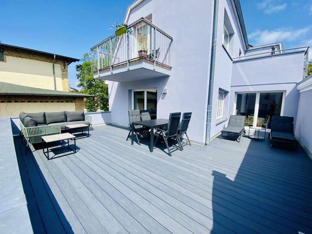 Wohnzimmer mit Sofa, Fernseher und Terrasse.