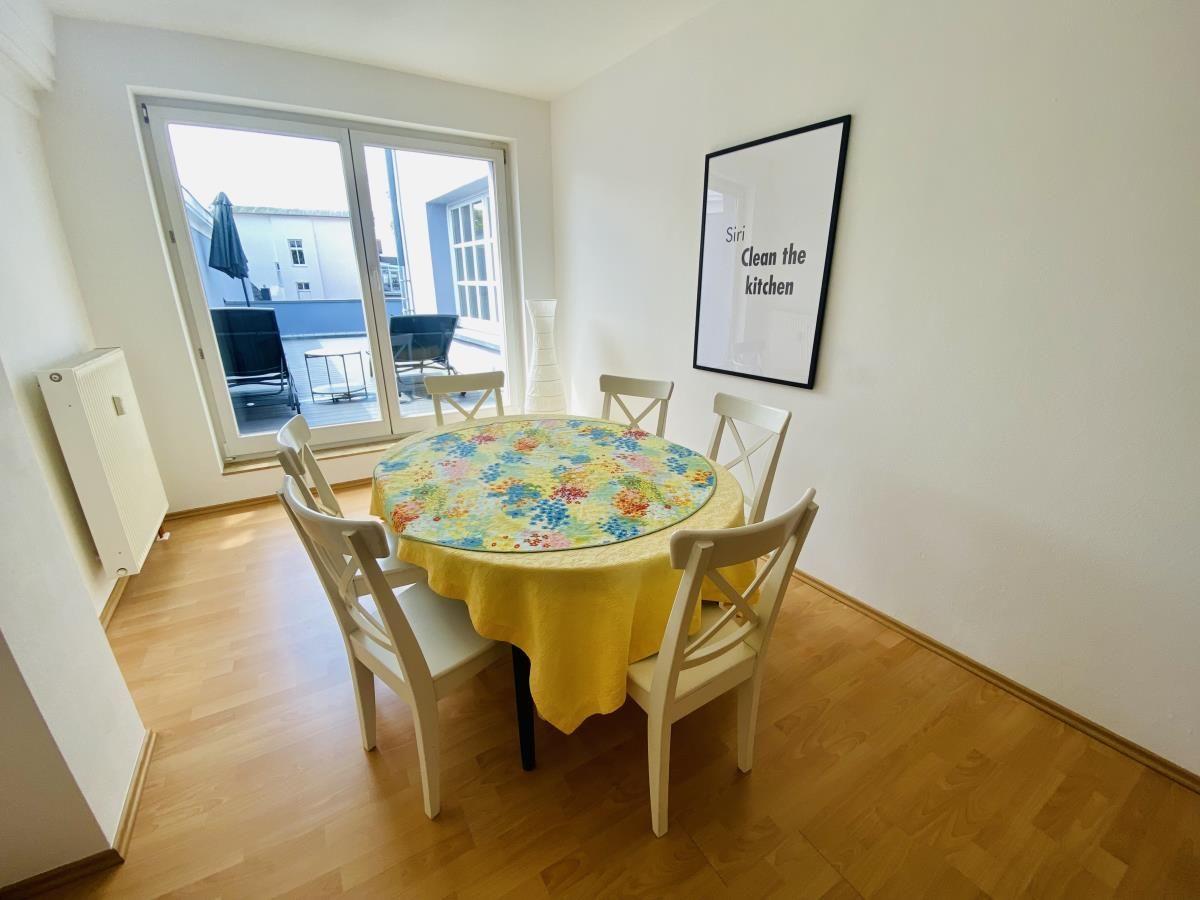 Schlafzimmer mit Doppelbett, Holzboden und Fenster mit Blick auf Bäume.