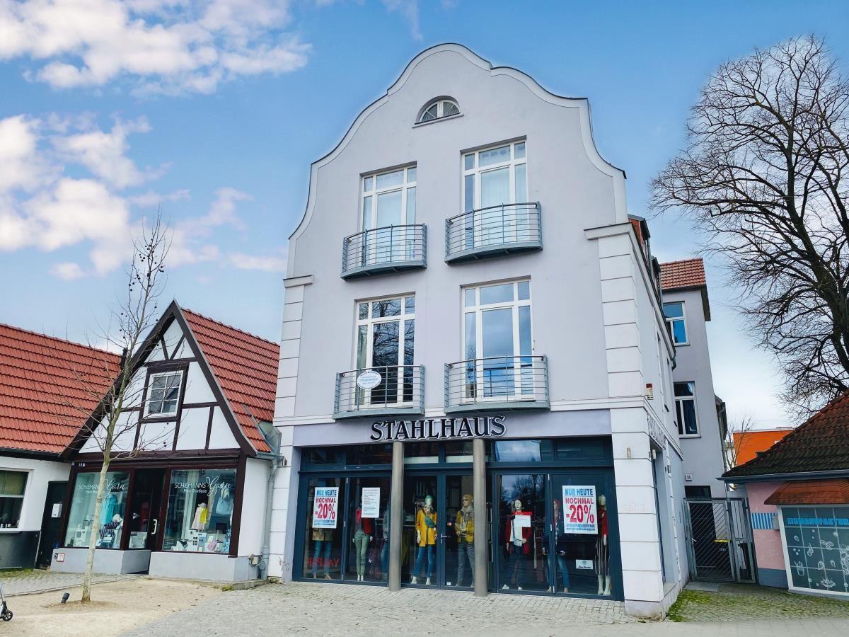 Terrasse mit Sitzgruppe, Esstisch und Liegen. Hinterhof mit Balkon und Fenstern.