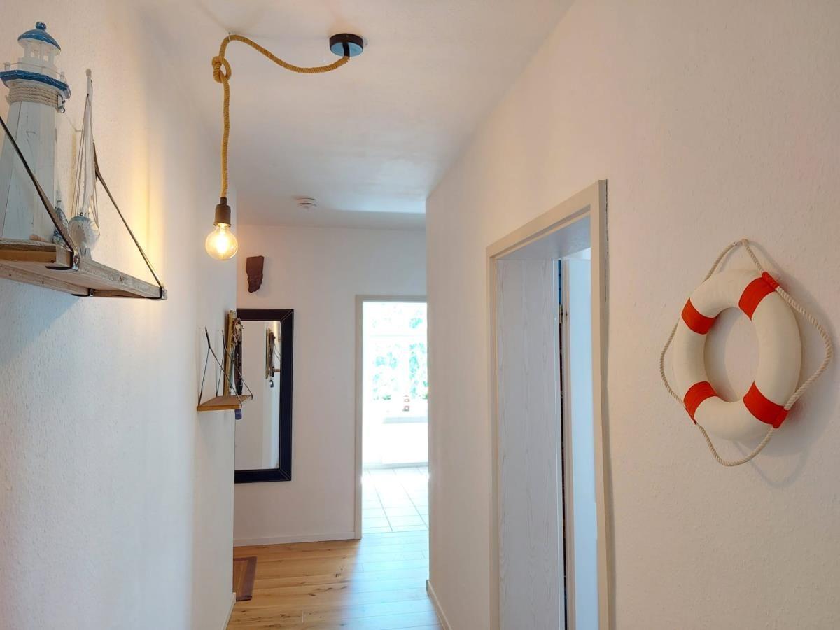 Bad mit Badewanne, Fenster, Duschvorhang und Heizkörper.