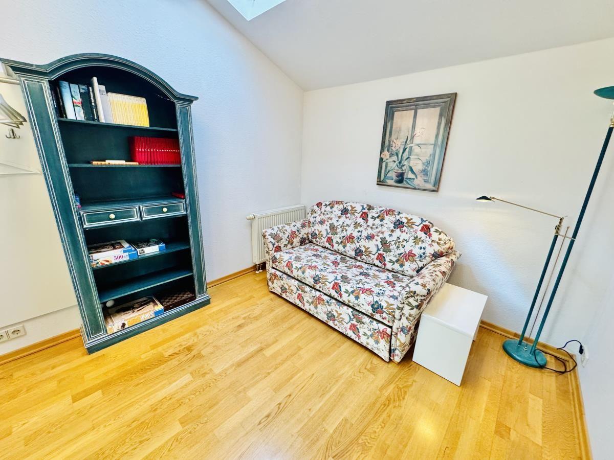 Flur mit goldrahmigem Spiegel, Teppich und Blick in Wohn- und Schlafzimmer.