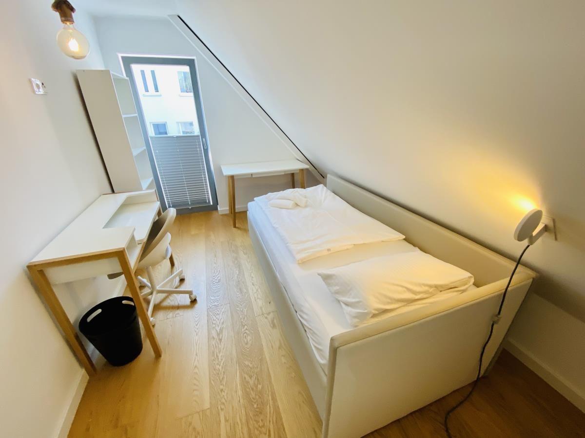 Helle Holzdielen, Treppe mit Holzgeländer, Pflanze und Fenster im Flur