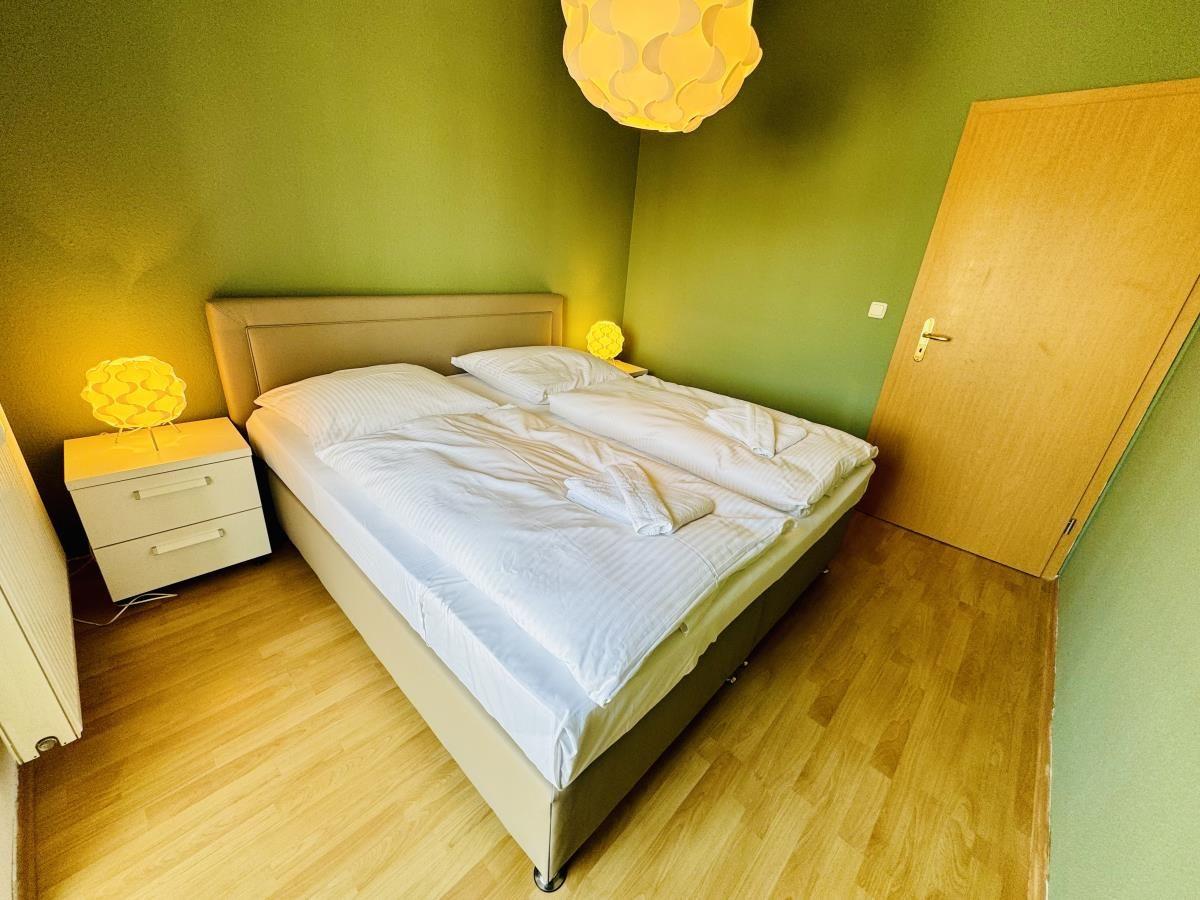 Flur mit Schrank, Blick in Küche und Wohnzimmer mit Sessel.