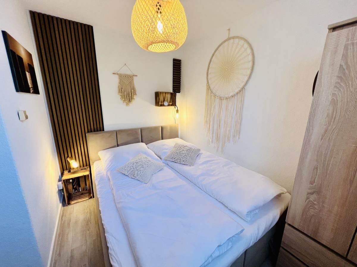 Schlafzimmer mit Bett, Nachttisch und Wanddekoration.
