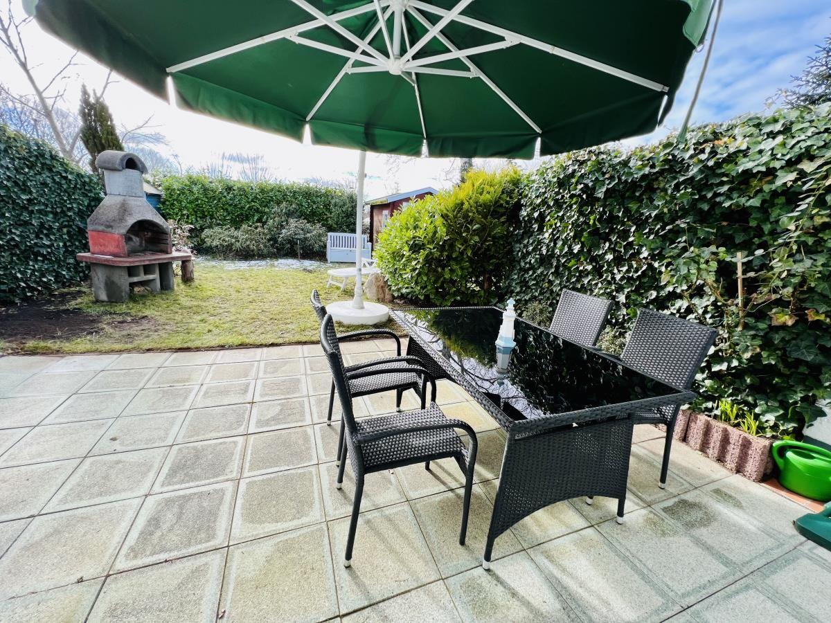 Wohnzimmer mit Sofa, Sessel und Esstisch im Hintergrund.