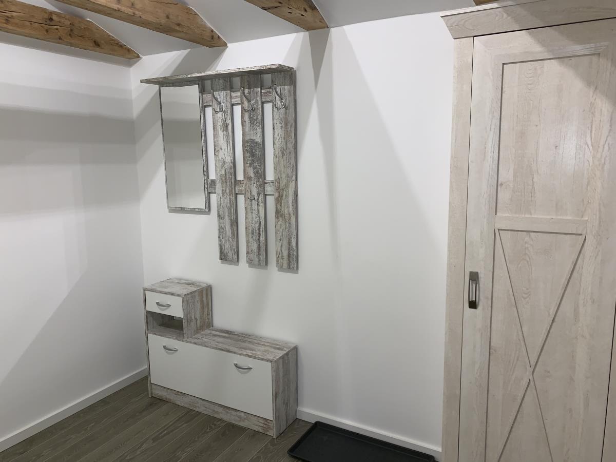 Flur mit Holzboden, Treppe und Wandbildern mit Meeresmotiven.