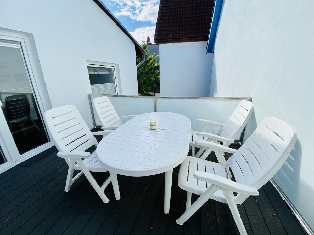 Haus mit Schild Seekiste zur Krim an einem gepflasterten Weg mit Hecken und Bäumen.