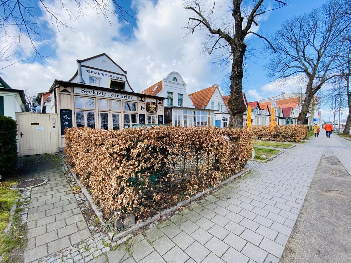 Haus mit Schild Seekiste zur Krim und Bäumen im Vorgarten