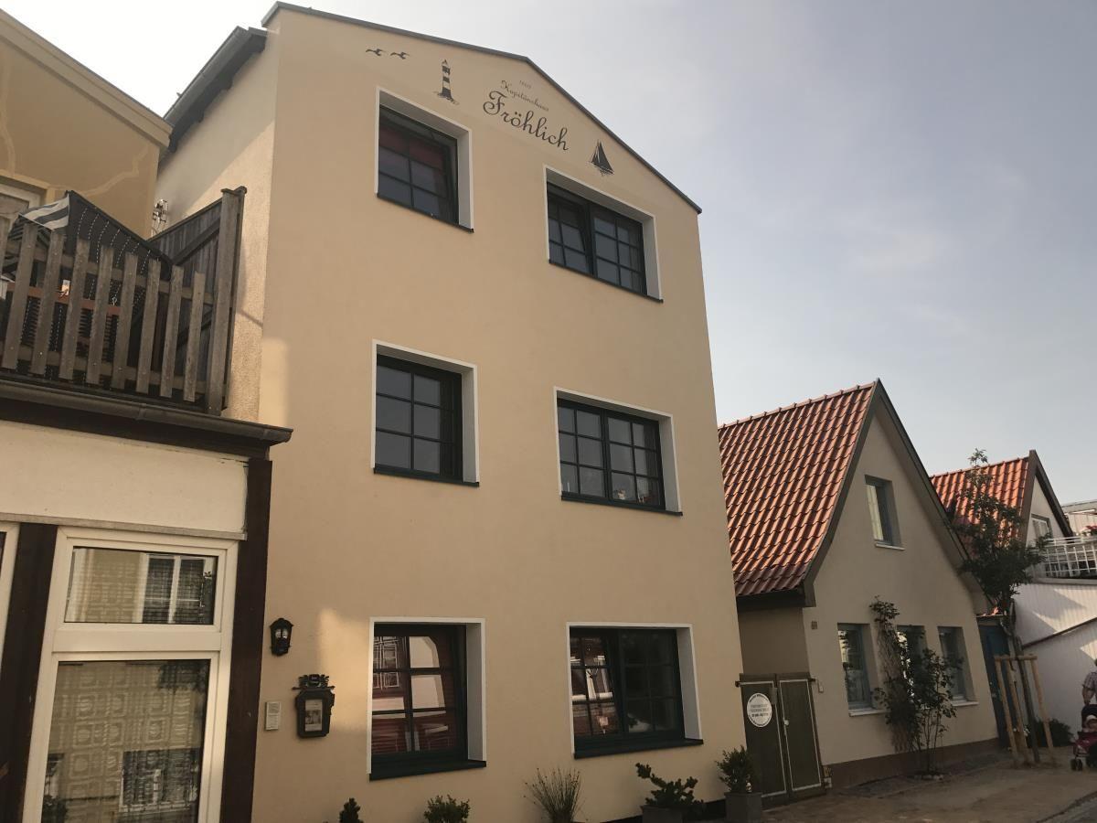 Hinterhof mit Pflasterweg und Rettungsring an Hauswand.