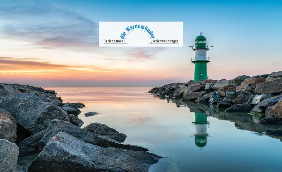 Sonnenaufgang über dem Meer, sandiger Strand und Strandgräser im Vordergrund.