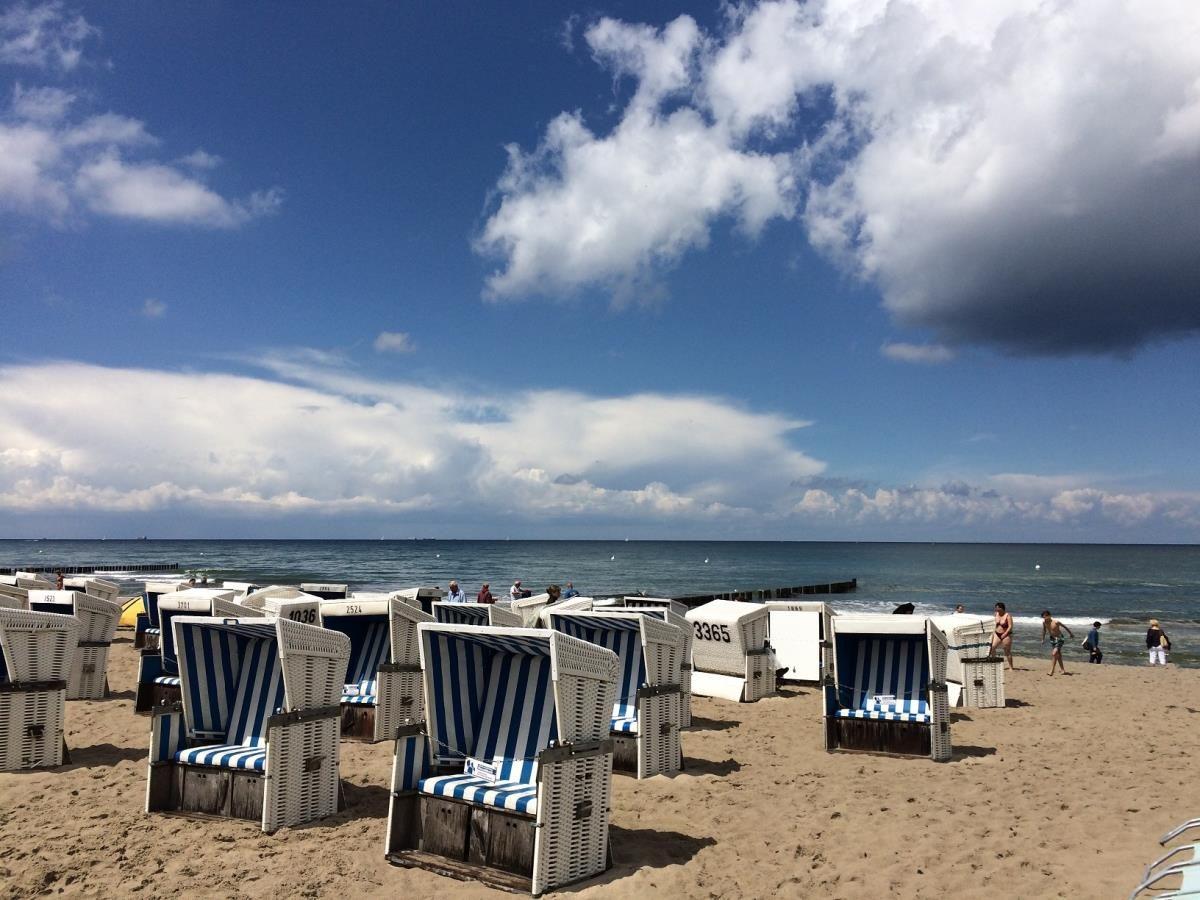 Großes Kreuzfahrtschiff vor Leuchtturm an Steilküste