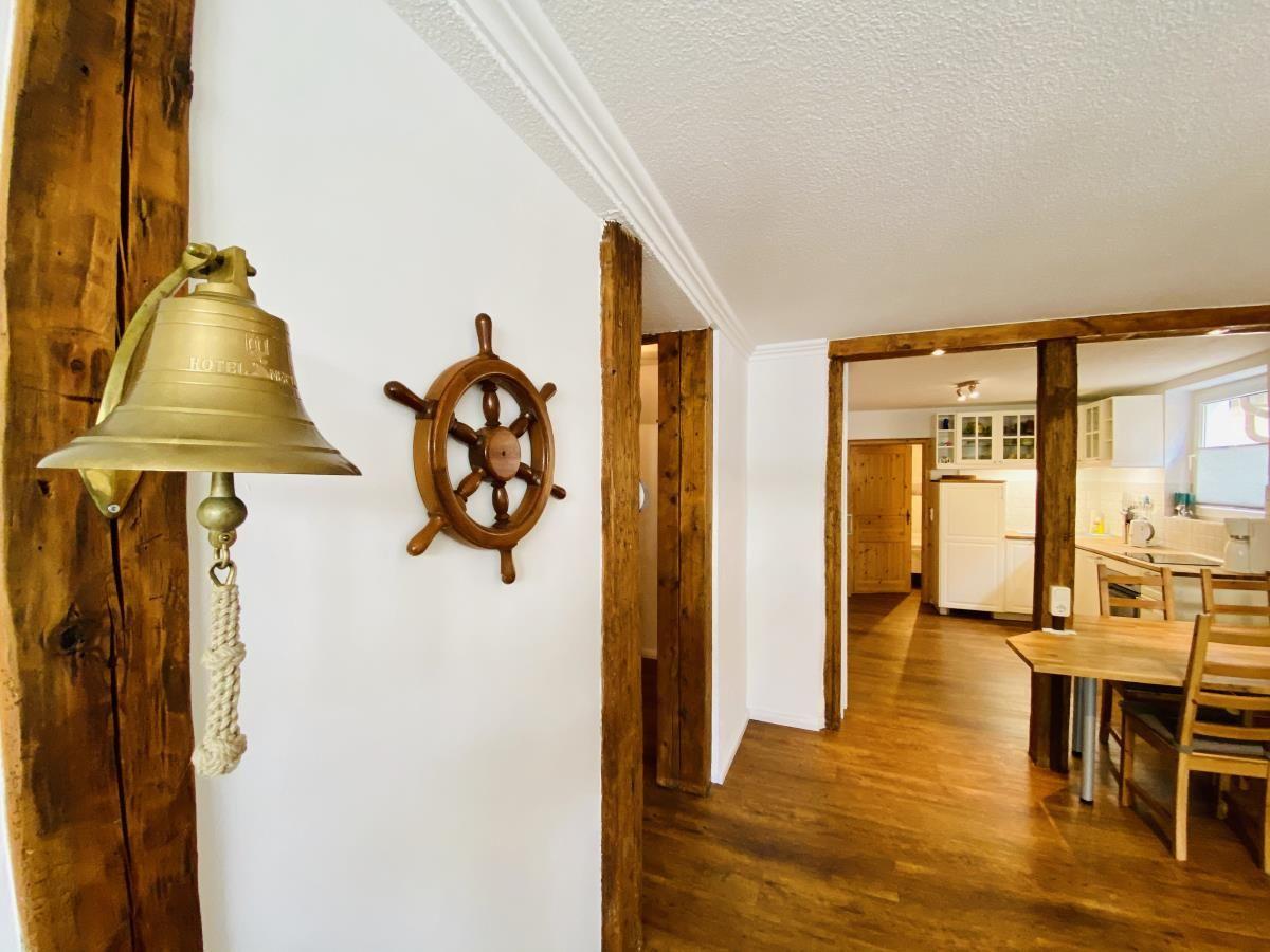 Schlafzimmer mit Bett, Kleiderschrank und Wandbild mit Palmenmotiv.