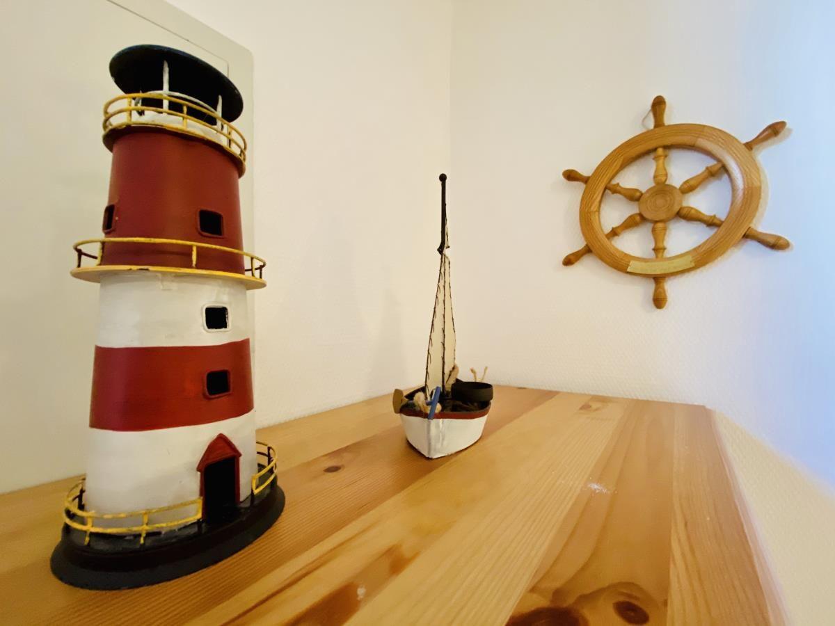 Hinterhof mit Holzgeländer, Tisch und zwei Stühlen vor Eingangstür.