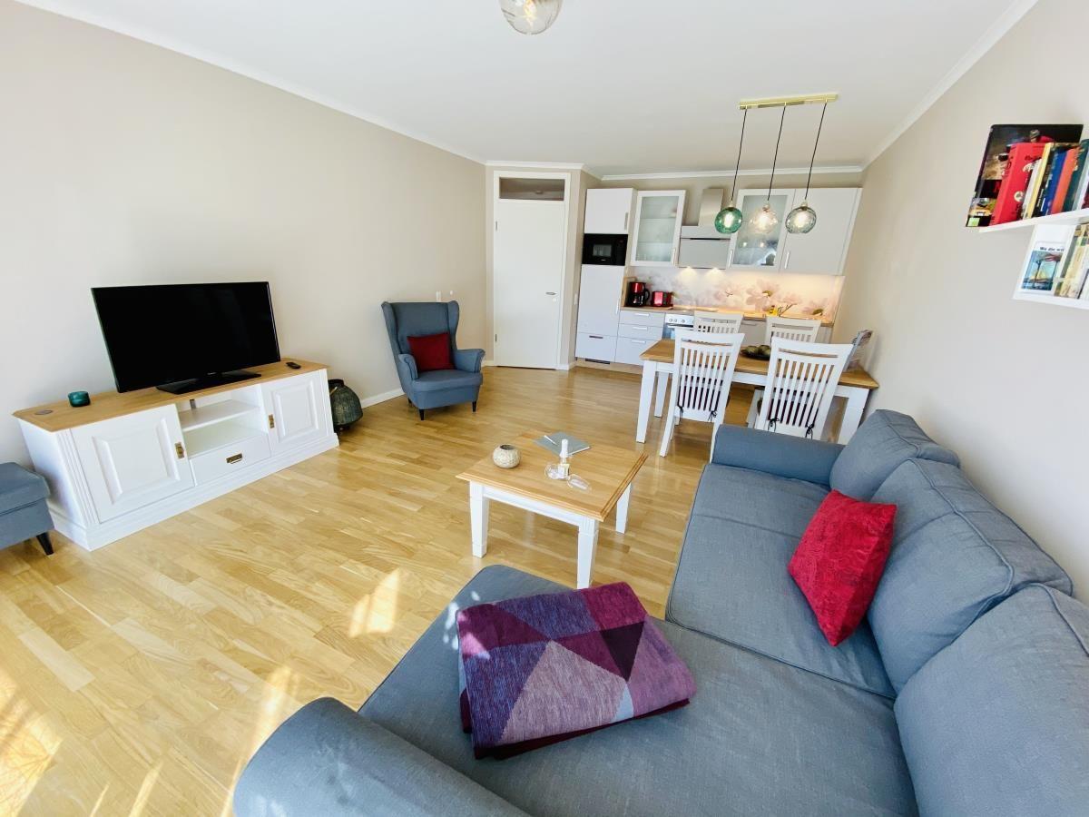 Wohnzimmer mit Sofa, Fernseher und Holzboden