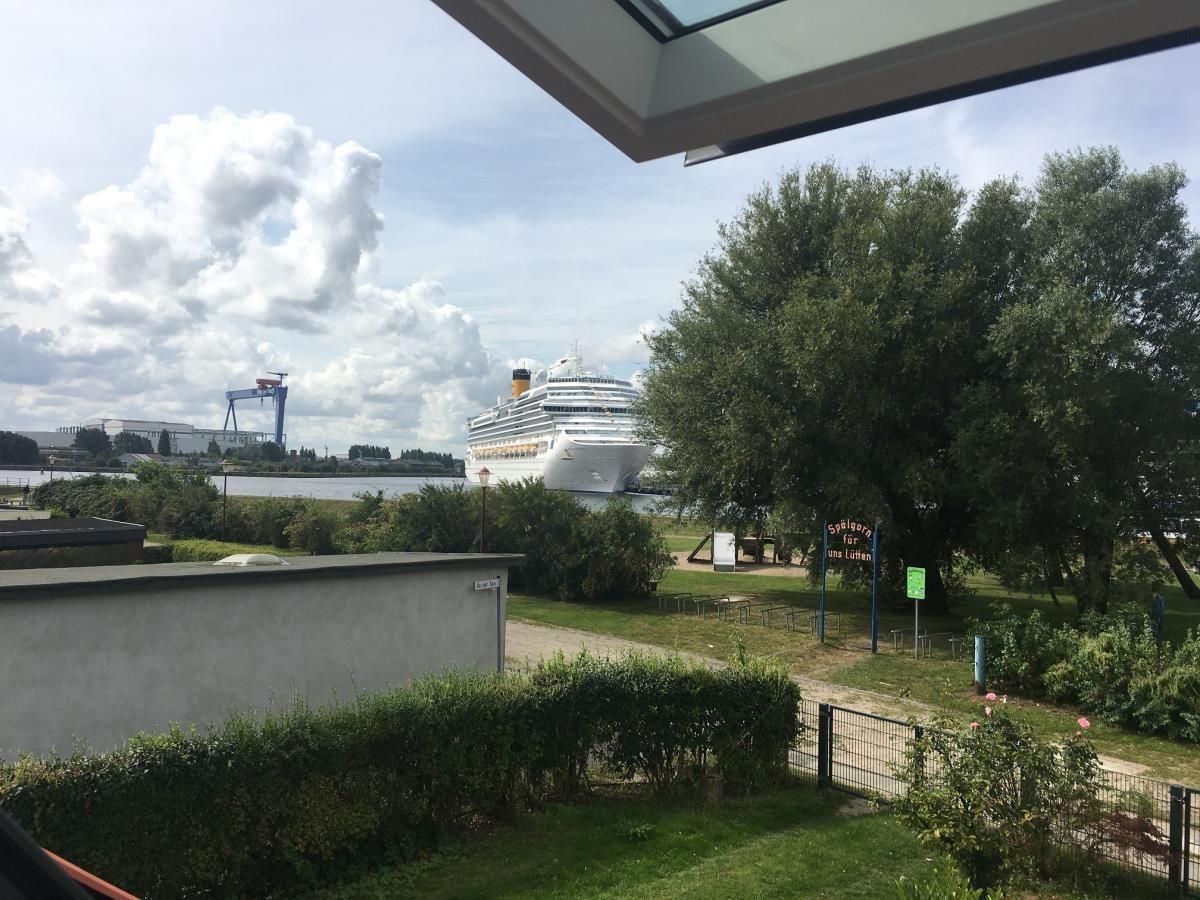 Nachtansicht von zwei Schiffen im Hafen: ein Kreuzfahrtschiff und ein Segelschiff mit beleuchteten Masten.