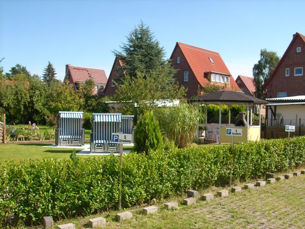 Gelbes Haus mit Balkonen und Terrassen. Hinterhof mit Steinmauer und Sitzgelegenheit.