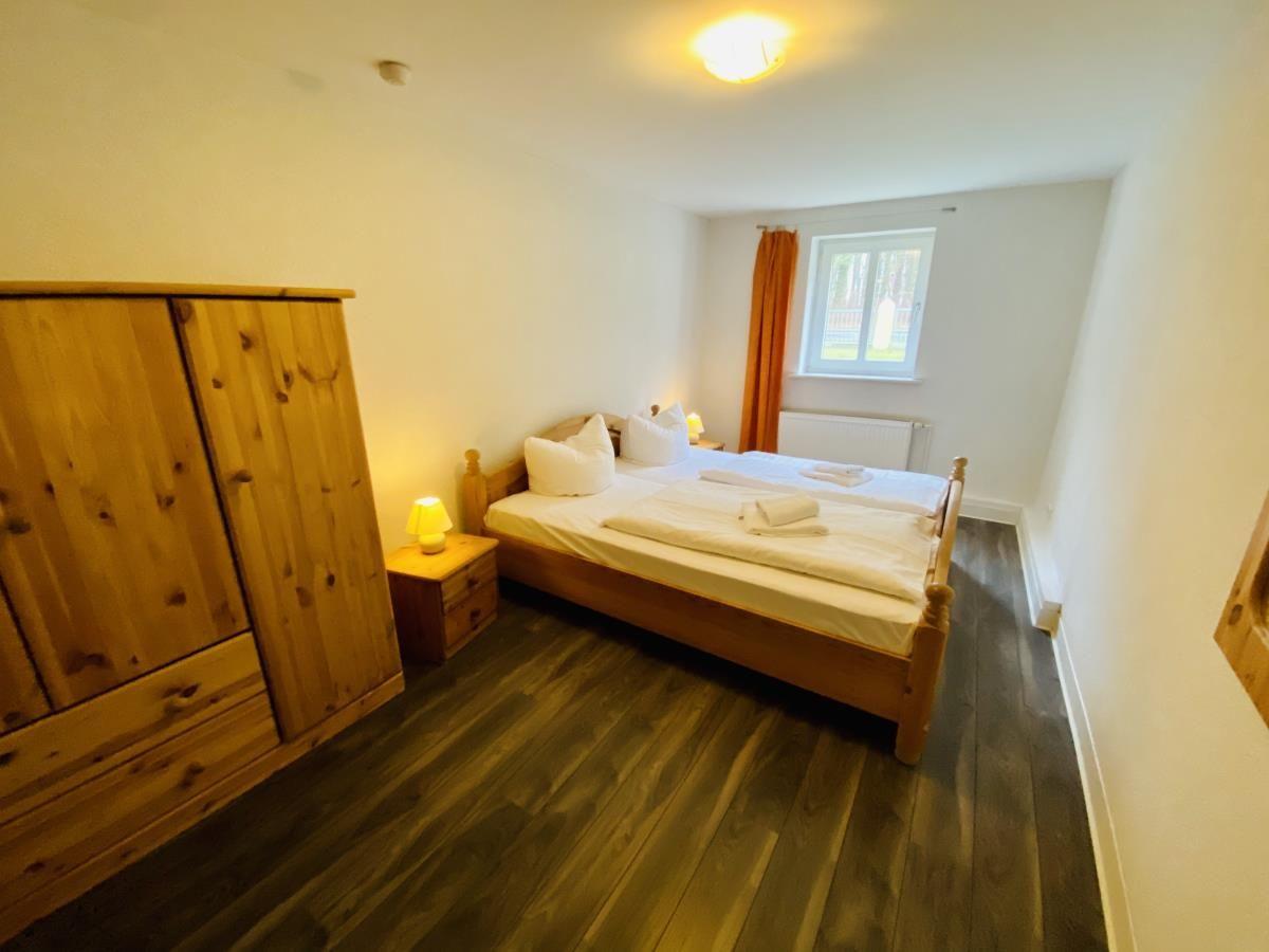 Zimmer mit Holz-Etagenbett, Fenster und Heizung.