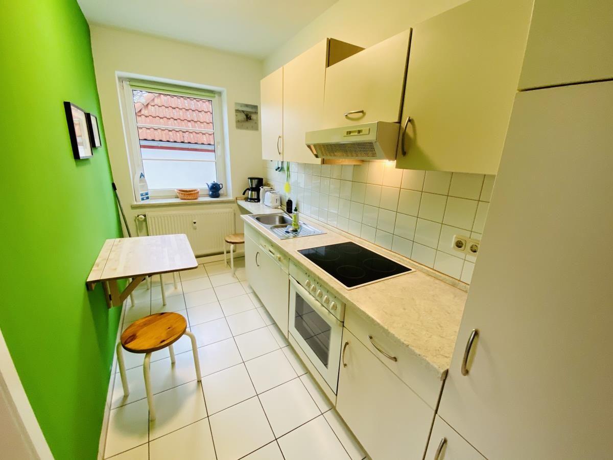 Schlafzimmer mit Bett, Kleiderschrank und Schminktisch mit Spiegel.