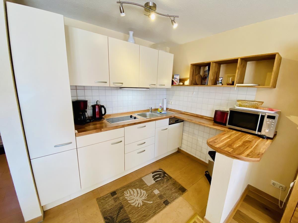 Ein Schlafzimmer mit Holzbett, Kleiderschrank und Wandbild.