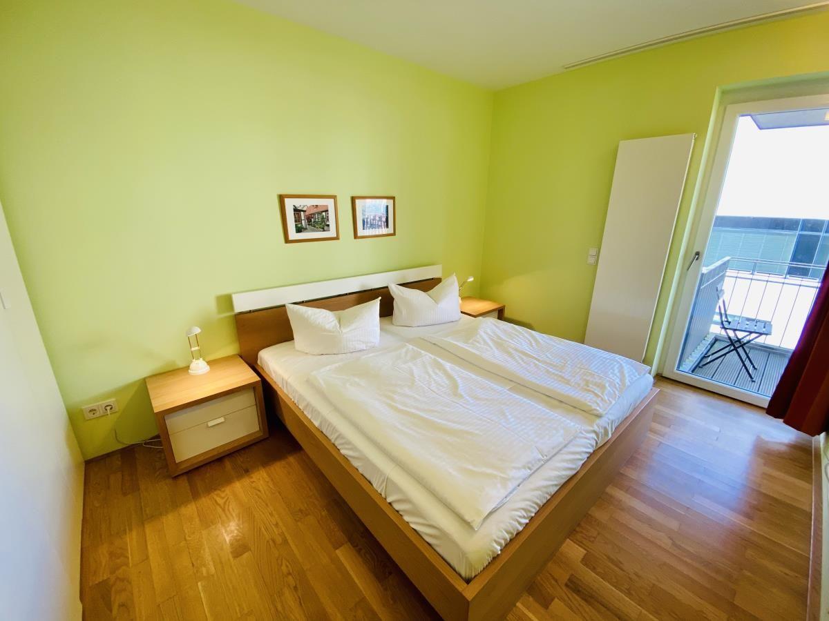 Waschmaschine und Trockner in einem Raum mit weißen Wänden und Fliesenboden.