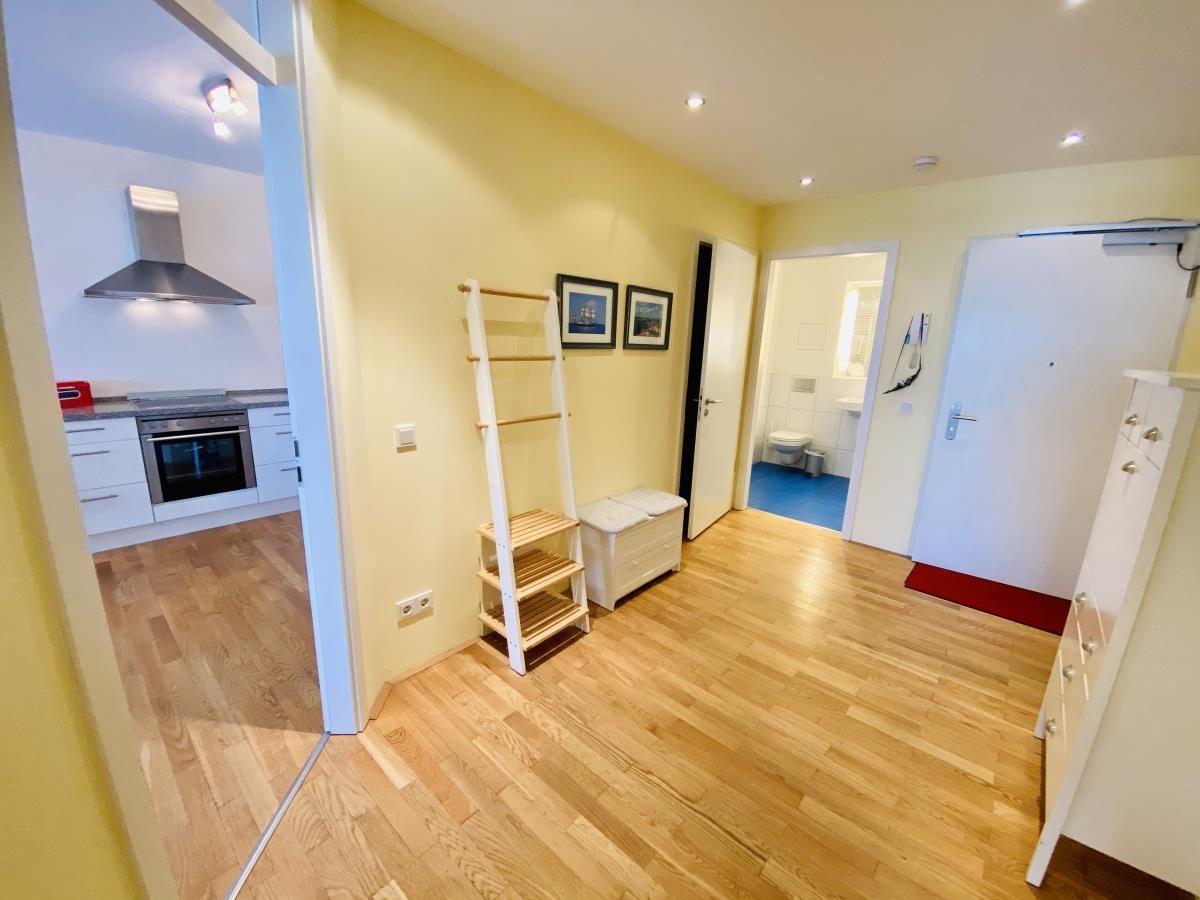 Flur mit Schrank, Kleiderständer und Blick in Schlaf- und Wohnzimmer.