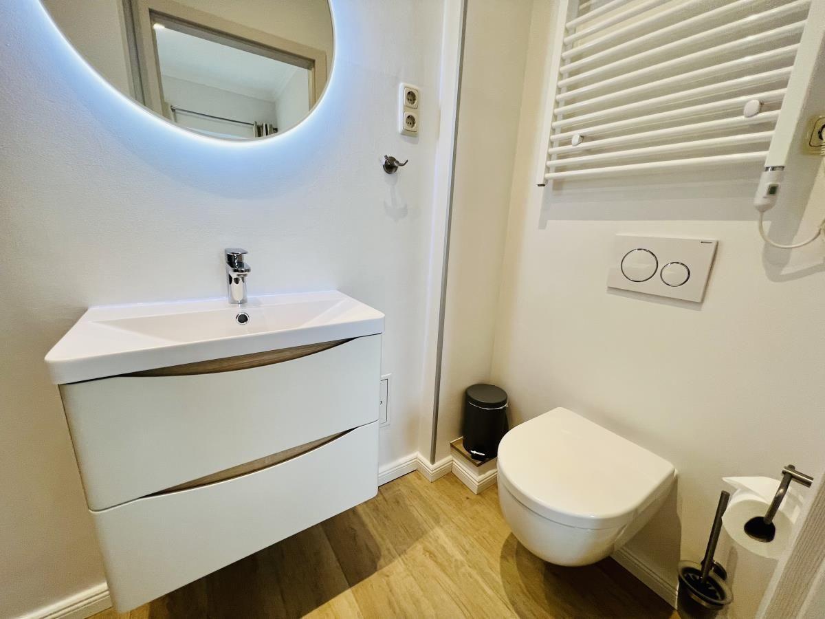 Badezimmer mit Dusche, Waschbecken und Toilette