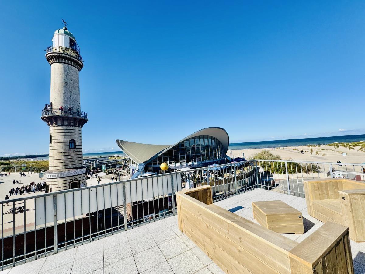 Großes Kreuzfahrtschiff am Hafen mit moderner Anlegestelle und blauem Himmel.