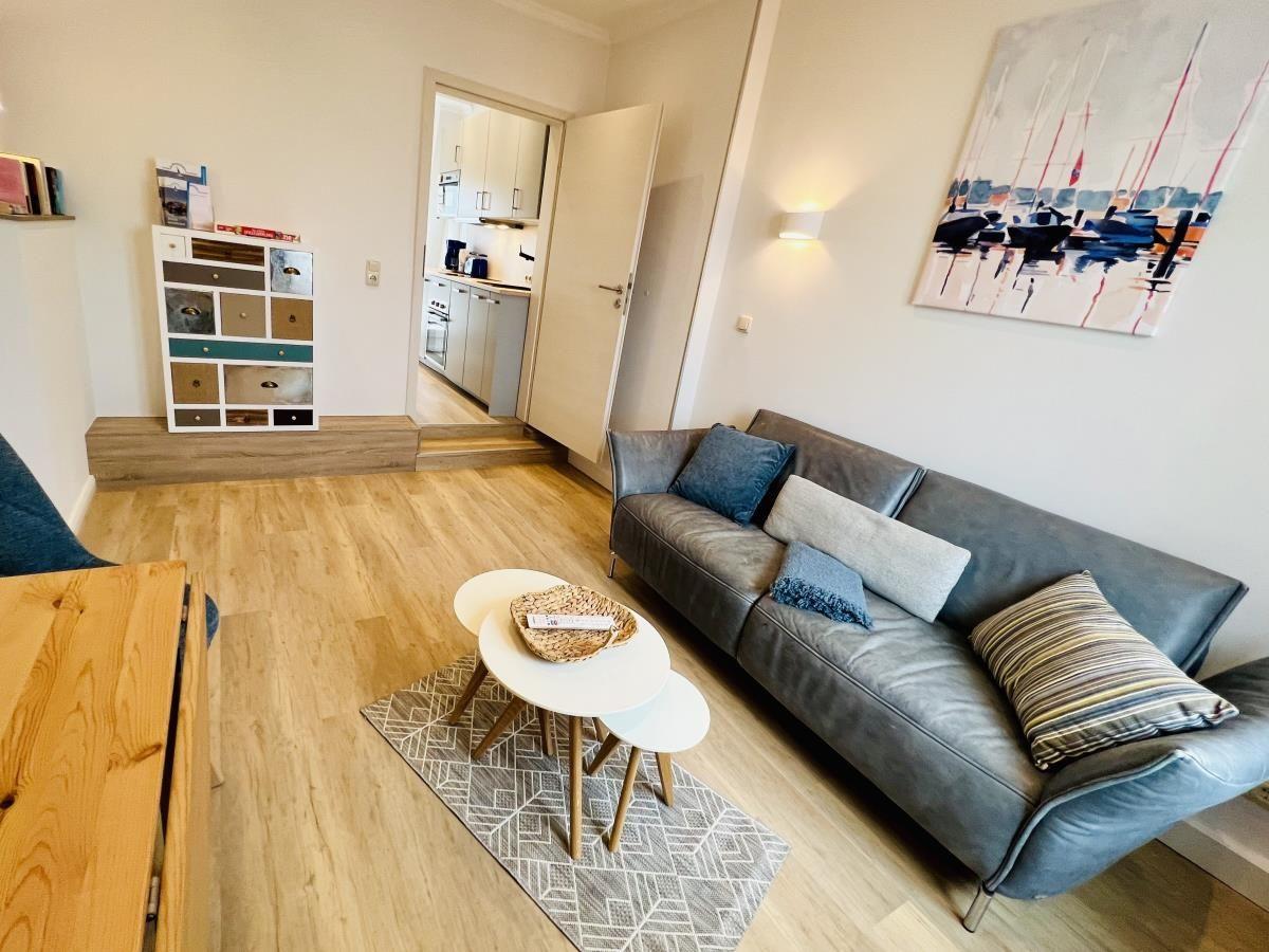 Wohnzimmer mit Sofa, Schreibtisch und Blick auf Dach