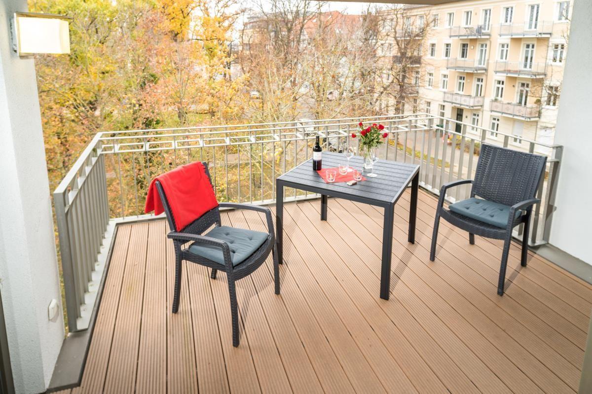 Blick von Balkon auf historisches Gebäude mit Bäumen