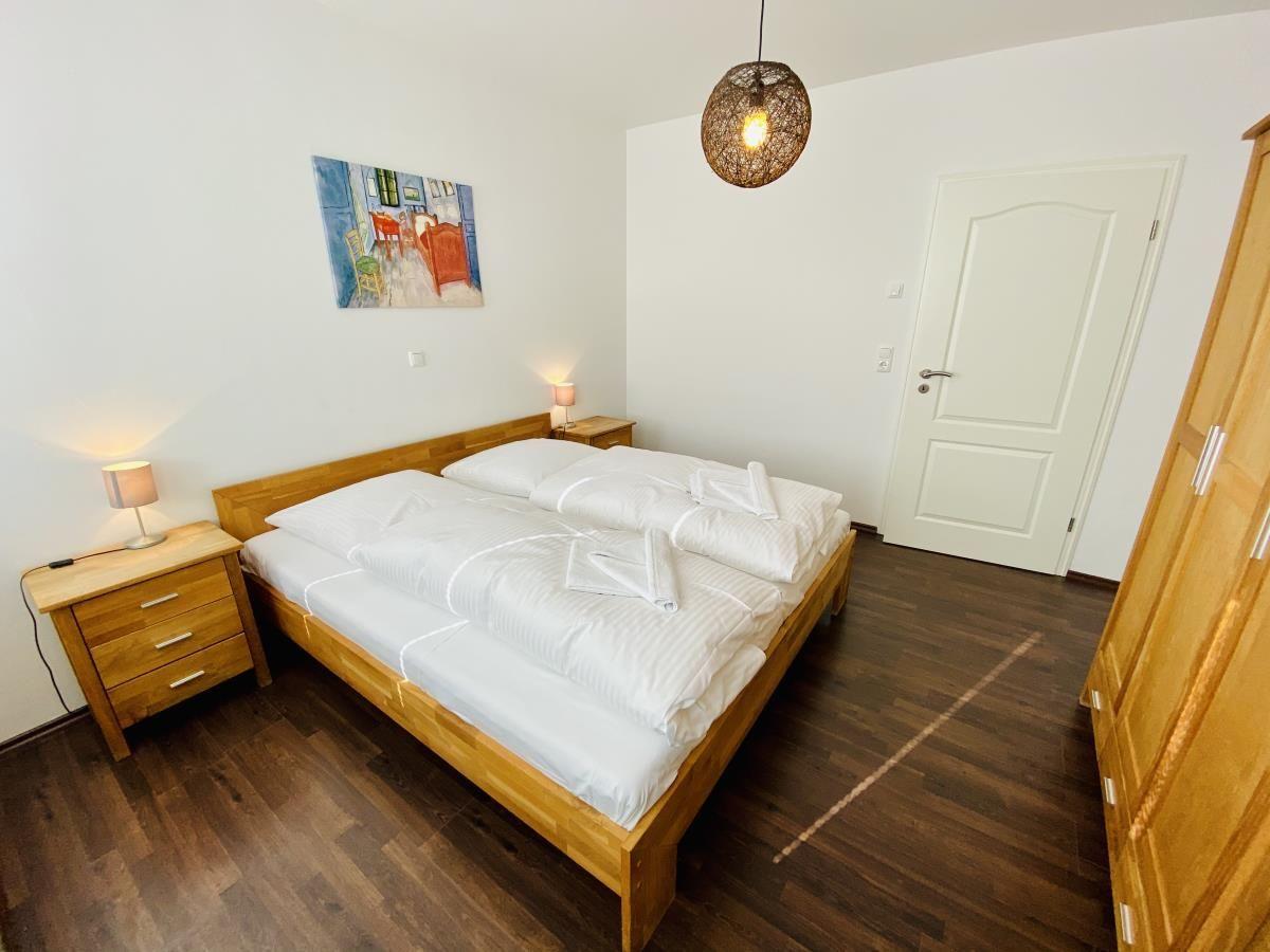 Schlafzimmer mit Doppelbett, Schrank, Nachttischen und Fernseher.