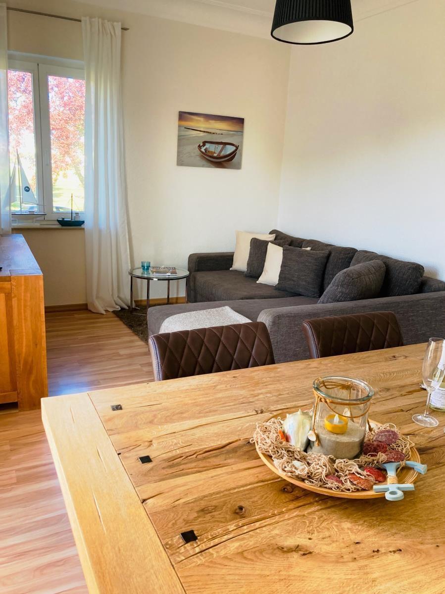 Wohnzimmer mit Sofa, Fernseher und Fenster mit Blick auf Garten.