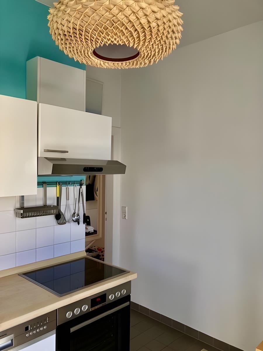 Küche mit Esstisch, Wandbild mit Fischen und Fenster mit Blick nach draußen.