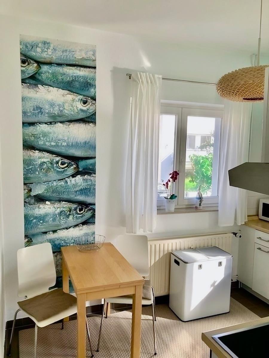 Küche mit Waschmaschine, Mikrowelle und Kochutensilien an der Wand.