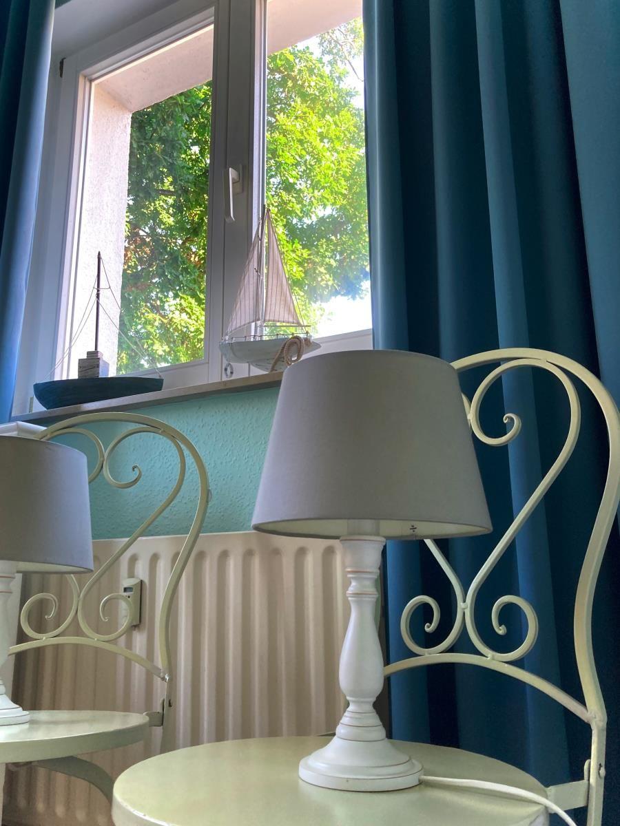 Zimmer mit weißen Schränken, Stuhl und Wanddekoration.