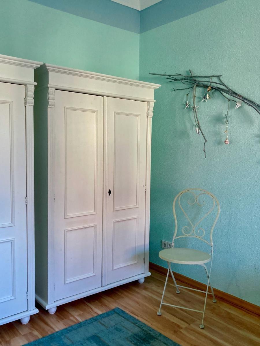 Badezimmer mit Waschbecken, Spiegel und Heizkörper an der Wand.