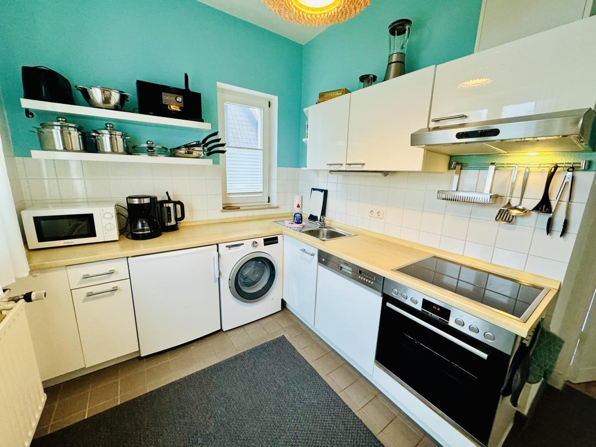Schlafzimmer mit Holzbett, Kleiderschrank und Fenster zur Terrasse.