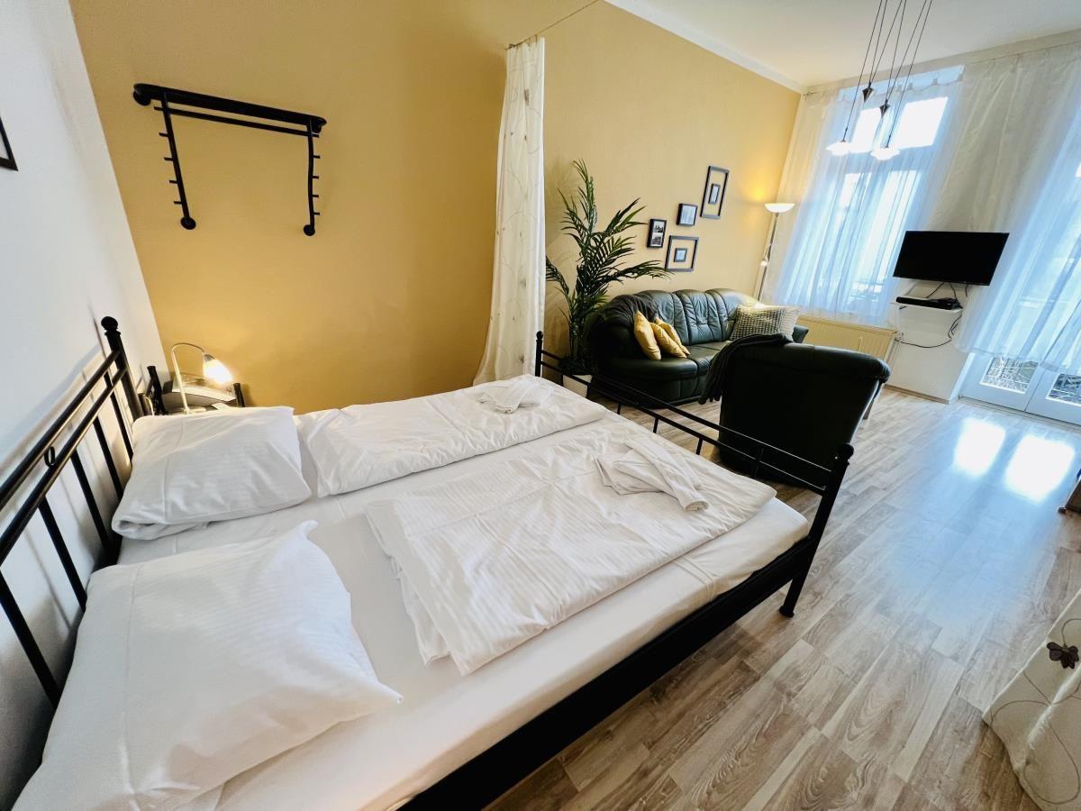 Schlafzimmer mit Doppelbett, Nachttisch und Wandbildern.