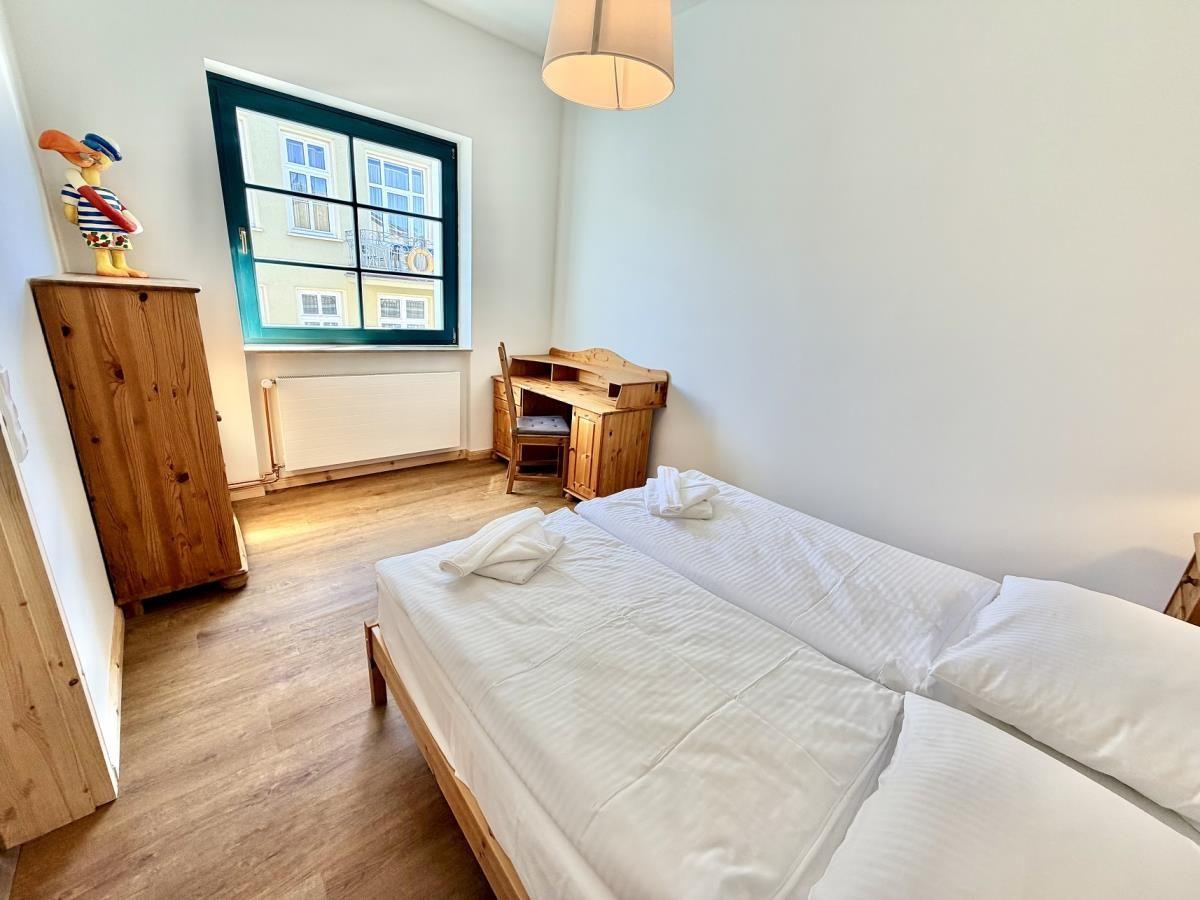 Schlafzimmer mit Doppelbett, zwei Nachttischen, Wandbild und Fernseher.