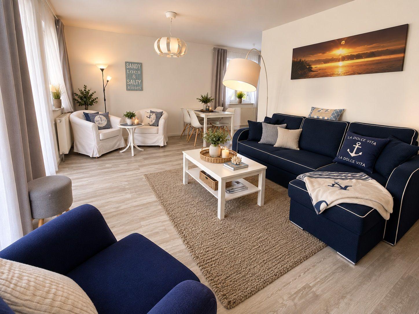 Wohnzimmer mit Sofa, Sitzgruppe und Esstisch. Wandbild und Dekoration im nautischen Stil.