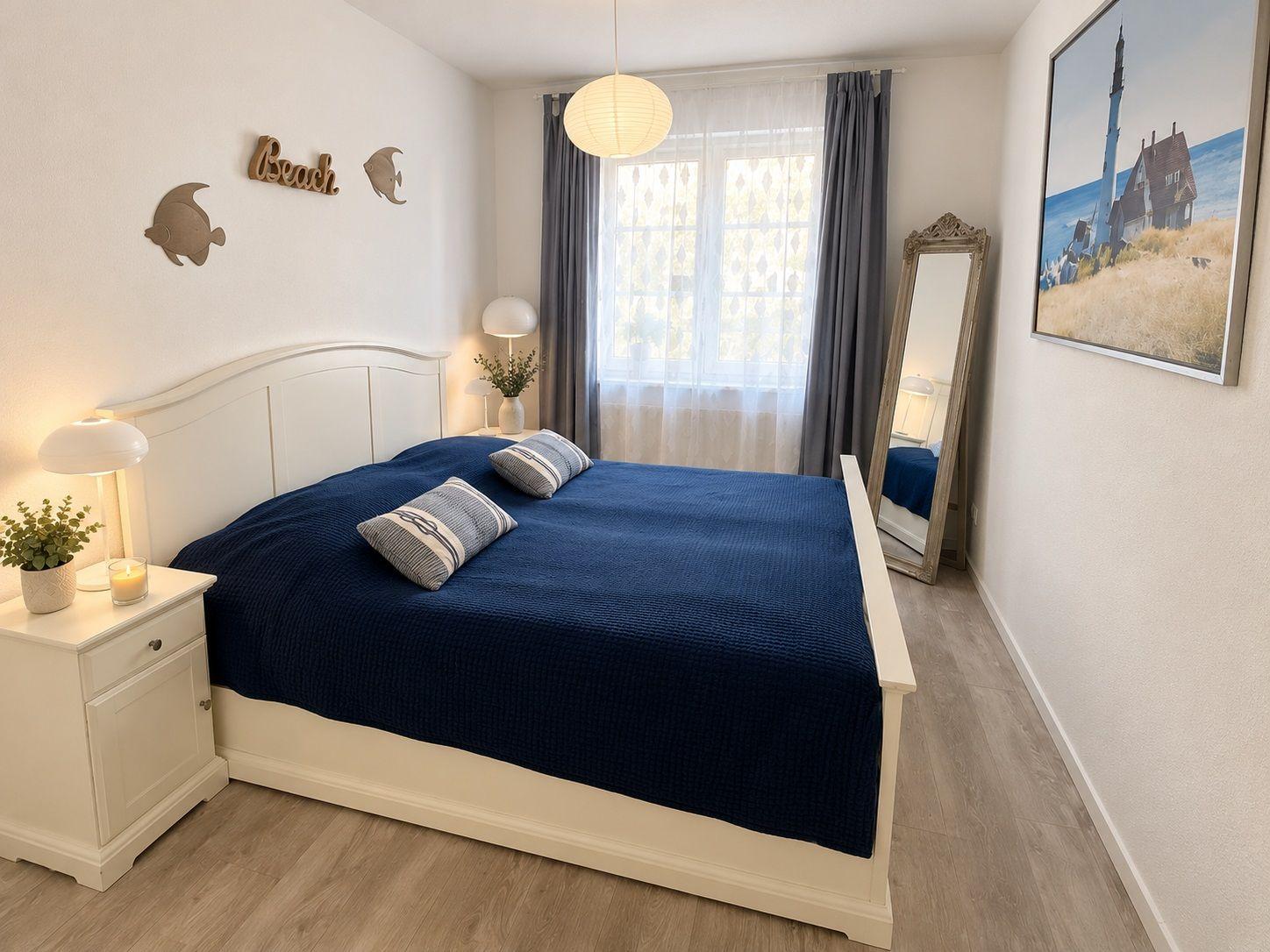 Schlafzimmer mit Bett, Nachttisch, Wandbild und Spiegel