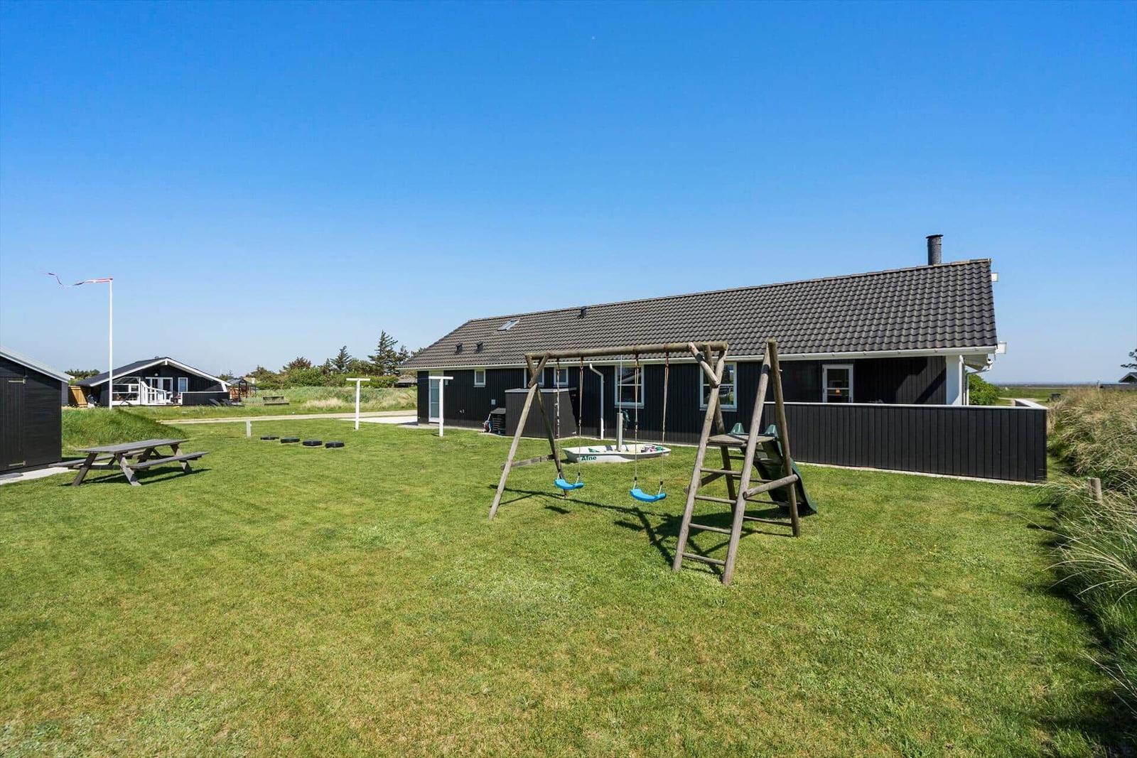 Weiterer Blick auf das Meer mit Strand und Dünen im Vordergrund.