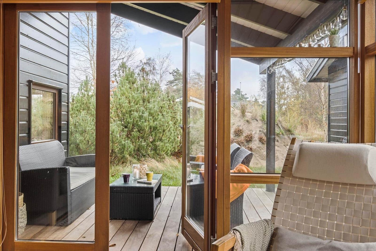 Terrasse mit Grill, Sitzgelegenheiten und Blick in den Garten.