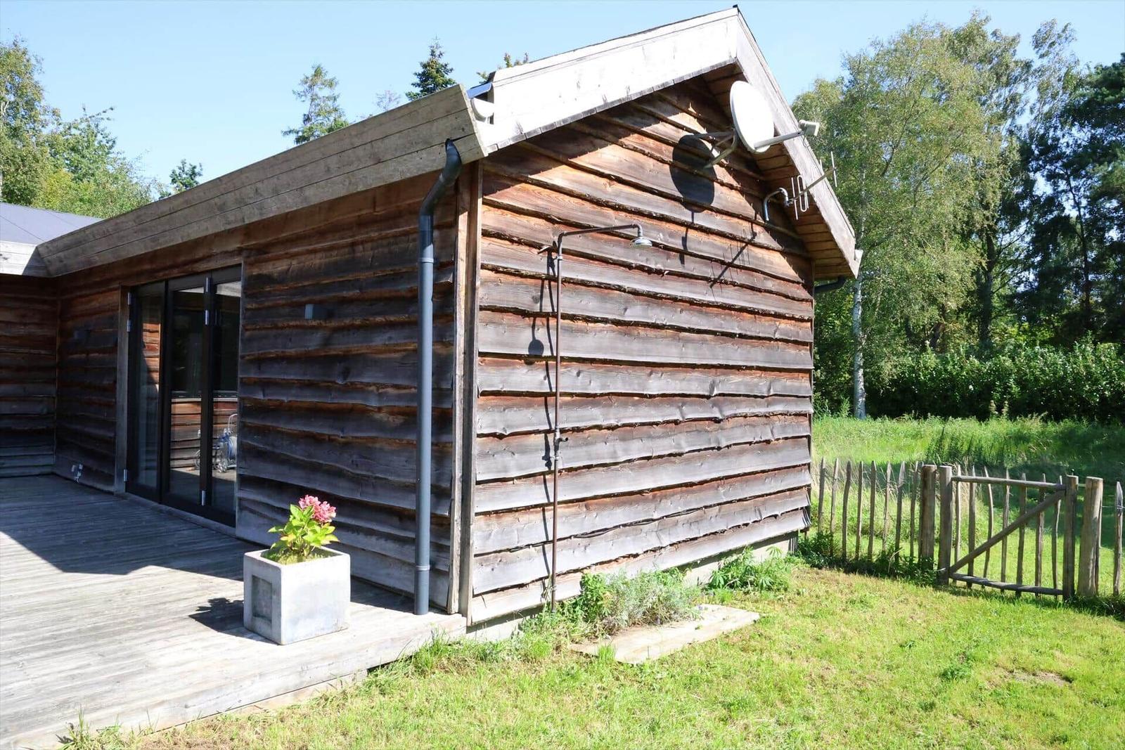 Wohn- und Essbereich mit Holzboden, zwei Ledersessel und großem Tisch.