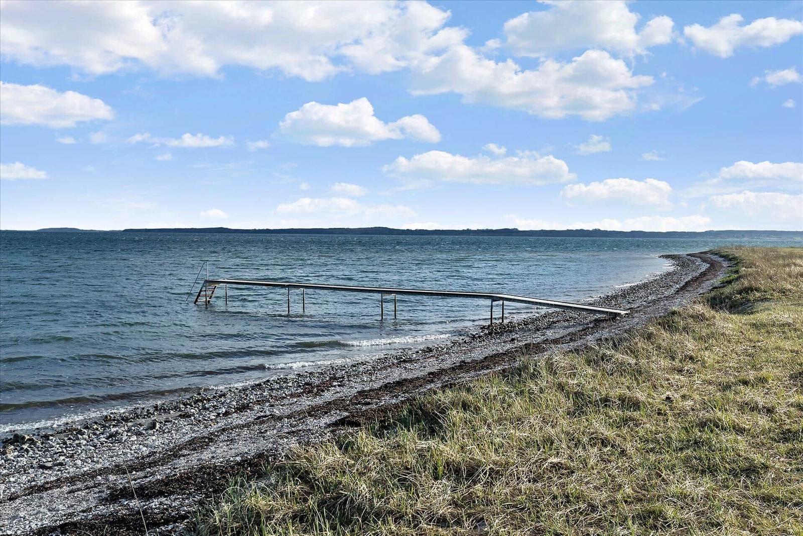 Raum mit Kaminofen, Kupferbadewanne und Fenstern mit Blick auf die Natur.